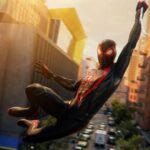 Marvel's Spider-Man 2 - Miles Morales balanceándose entre los rascacielos de Nueva York con su traje negro y rojo