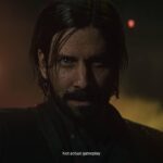 Alan Wake 2 - Alan Wake iluminado por luces de neón en una escena nocturna del Lugar Oscuro