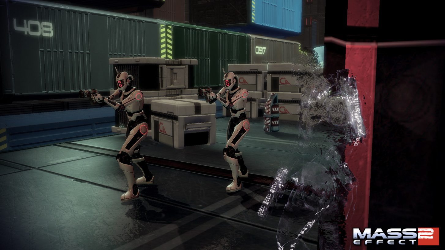 Mass Effect 2 - Un personaje con camuflaje táctico acecha a dos mercenarios en una zona de carga
